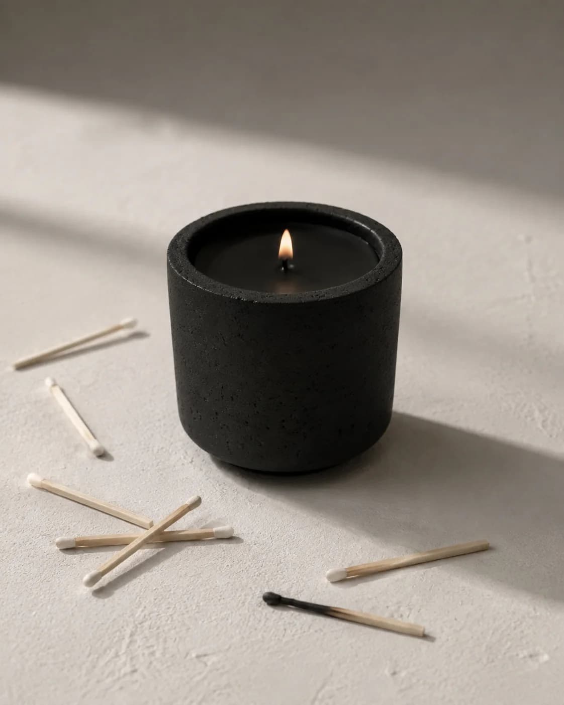 the andromeda candle lit, wooden matches scattered beside it, one spent