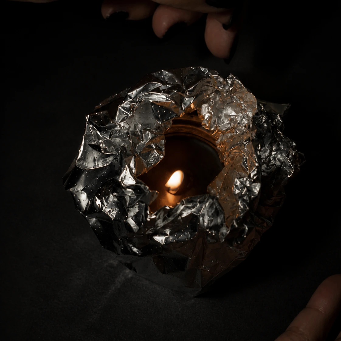 A foil collar wrapped around a burning candle to fix tunneling