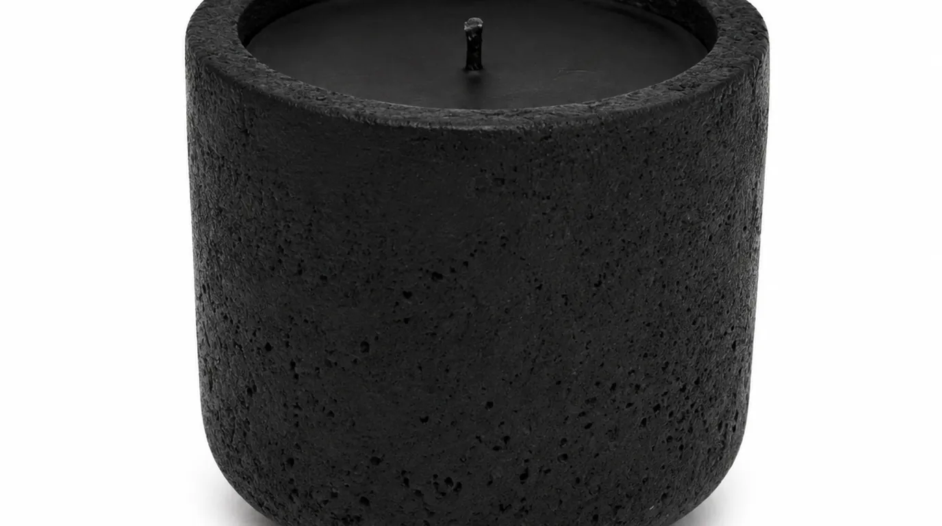 A candle in a minimal setting on a clean surface with soft natural light